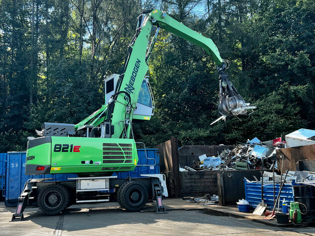 Ein Bagger mit Greifzange sortiert den angelieferten Schrott bei Hossfeld